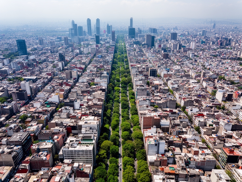 Vista aérea del barrio Nápoles en la Ciudad de México, zona urbana organizada con avenidas amplias y vegetación entre edificios, ambiente metropolitano ordenado
